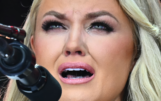 Erika Kirk, CEO of Turning Point USA speaking at the memorial service for her slained husband Charlie Kirk, 2025, Getty Images.